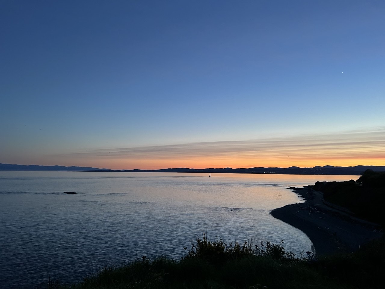 Sunset reflected across calm coastal water in Victoria, BC.